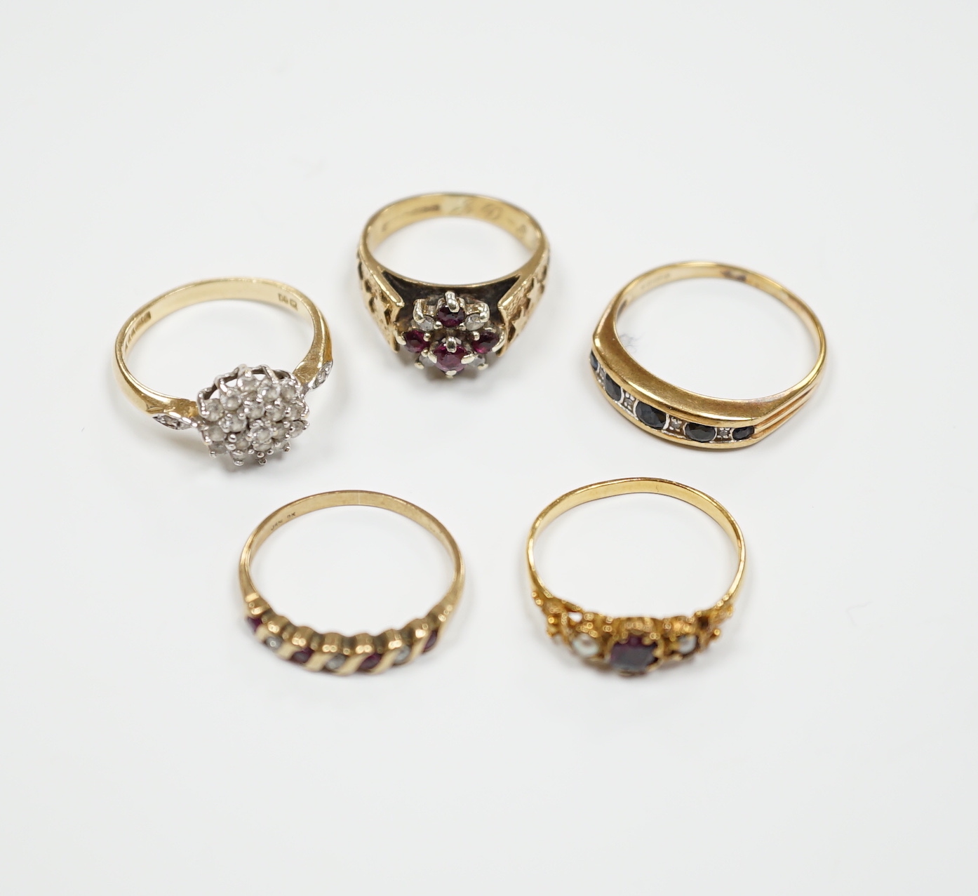 Three assorted 9ct gold and gem set rings, including ruby and diamond cluster, gross weight 7.7 grams, a 585 yellow metal and cubic zirconia set cluster ring and a yellow metal, garnet and seed pearl set ring, gross weig